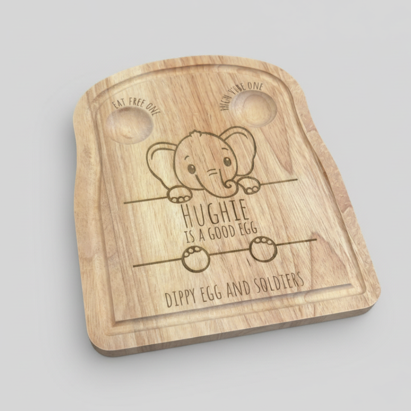 Wooden egg tray with engraved elephant design and text on a concrete surface with eggs around.
